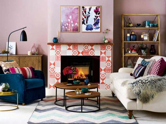 pink and red living room with mix of print and pattern with a fireplace