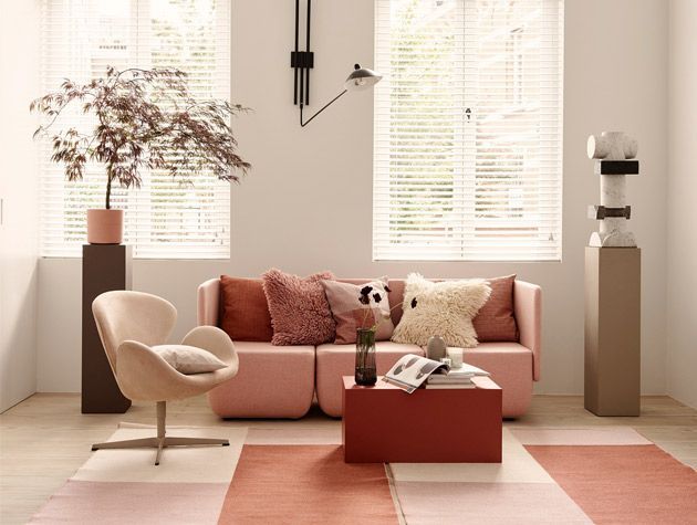 pared back style living room with pink sofa and apricot cushions