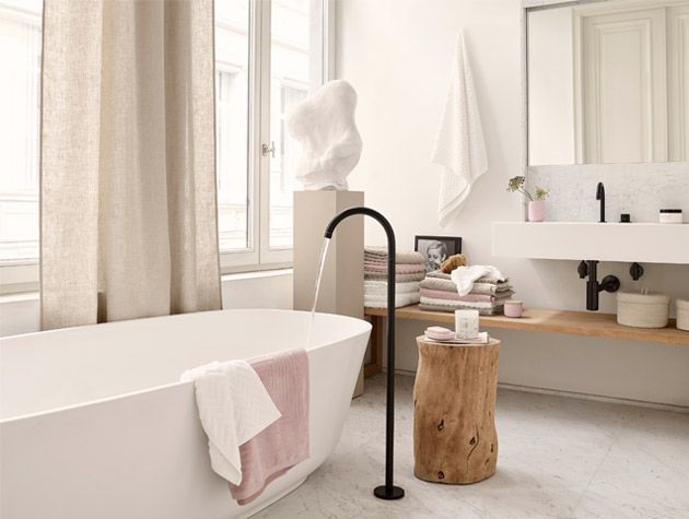 sensory bathroom with double sink freestanding bath and pink towels