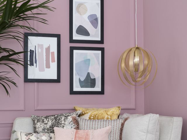 statement ceiling lighting and a selection of framed plant artwork above a sofa in front of a pink wall by bhs spring summer 2018