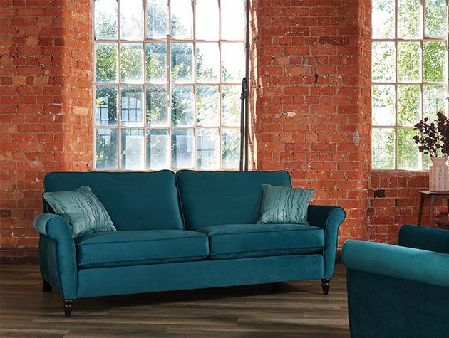 teal sofa in living room with brick wall