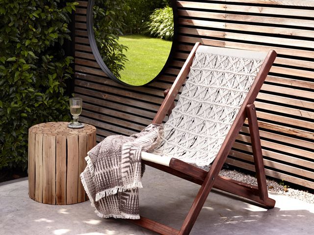 french connection outdoor space with deck chair, large mirror and wood backdrop