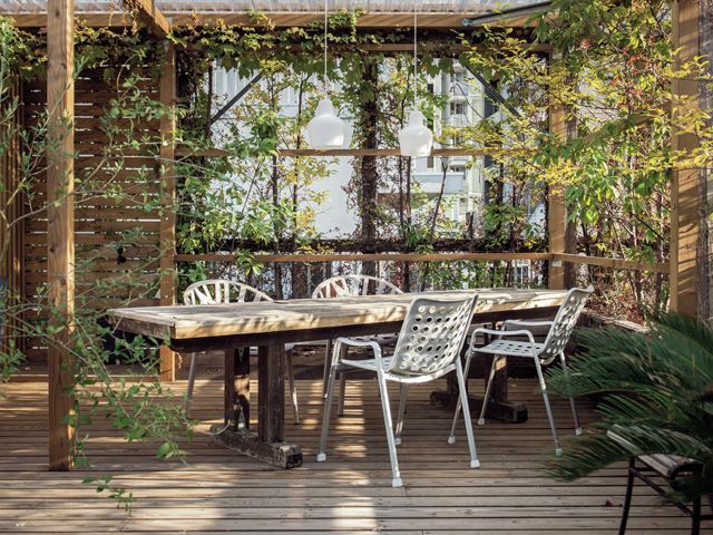 nest.co.uk wood table and white chairs in an outdoor dining room on a patio or balcony
