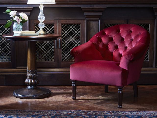 red button spoon chair and a glass lamp base from soho home's the ned collection