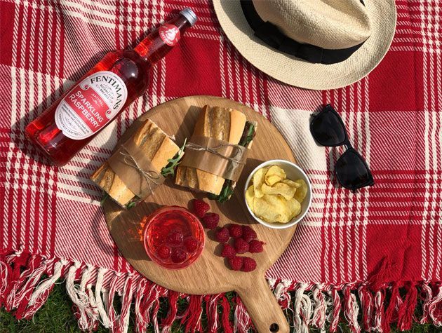 picnic spread with fentimans sparkling raspberry on red picnic blanket