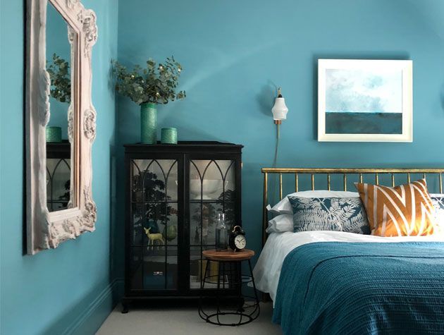 teal scheme bedroom with teal walls teal bedding and vintage furniture with gold and orange accents