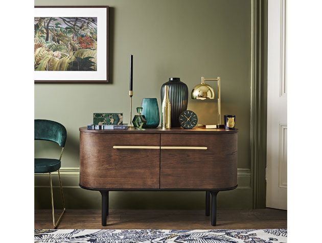 80s style dark wood side table with metallic ornaments placed on top in green painted room -john-lewis-goodhomesmagazine.com