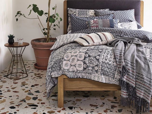 Bedroom with terrazzo flooring and bed dressed with ethnic patterned grey bedding -argos-home-living-room-goodhomesmagazine.com