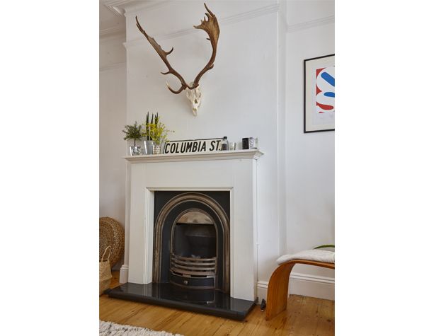 victorian fireplace in living room with stag skull ornament hung on wall above