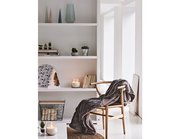 White Nordic themed living room with white display shelf and wooden chair with grey throw -sainsburys-home-living-room-goodhomesmagazine.com