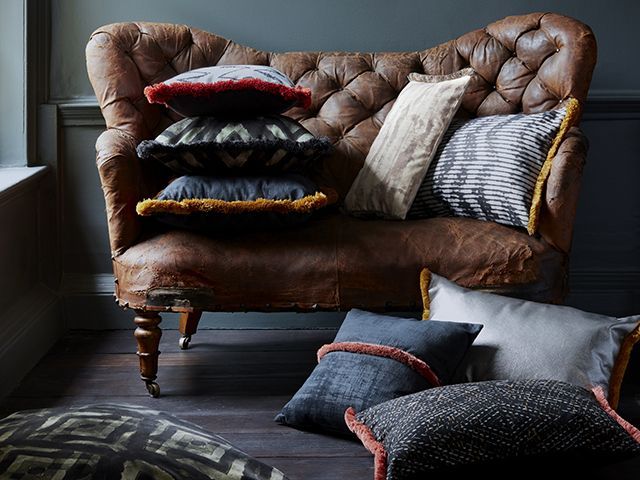 abigail ahern textiles and cushions for her debut hillarys collection on a brown leather sofa
