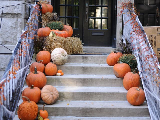 Halloween decorated front door staircase with pumpkins and cob webs -living-room-goodhomesmagazine.com