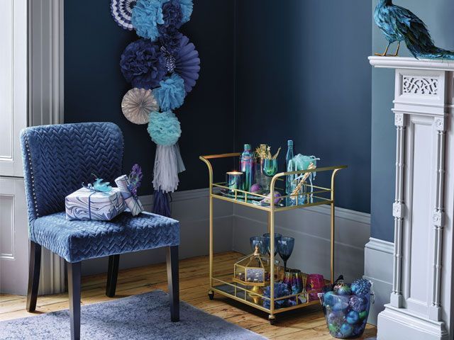 Blue scheme living room with gold bar cart and blue pom pom Christmas decorations -homesense-living-room-goodhomesmagazine.com