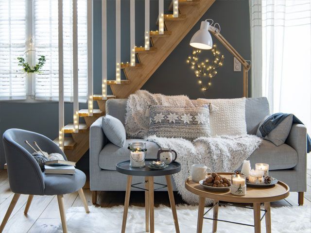 Grey scheme living room with Christmas decor including fairy lights, a hanging wreath and plus throws -maisons-du-monde-living-room-goodhomesmagazine.com
