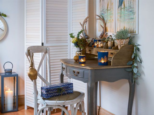 Desk area with grey and brown desk filled with Christmas decorations and candles from Lorraine Kelly's Christmas cottage makeover with Wayfair UK -wayfair-uk-home-tours-goodhomesmagazine.com