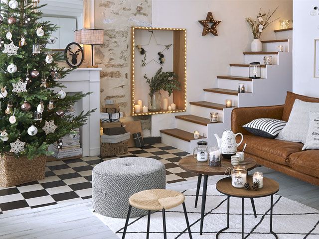 Living room with Christmas tree, festive decor, a brown sofa and grey layered rugs -maisons-du-monde-living-room-goodhomesmagazine.com