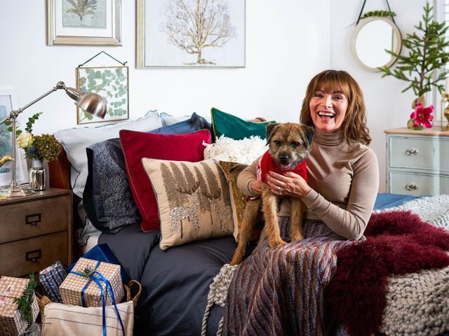 Lorraine Kelly sat with her dog Angus in the bedroom of her Christmas cottage makeover in partnership with Wayfair UK -wayfair-uk-home-tours-goodhomesmagazine.com
