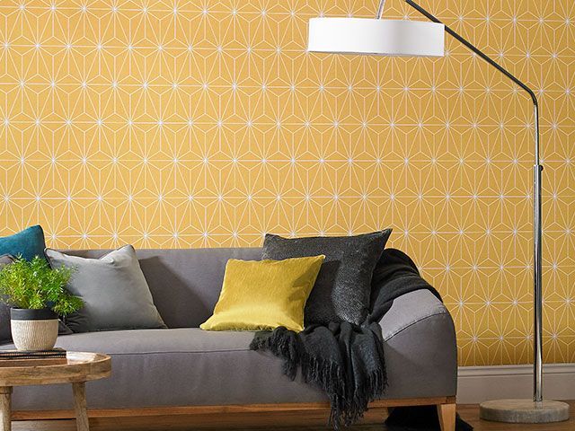 prism print wallpaper in yellow by Graham & Brown featured in a living room - wallpaper trends 2019 - goodhomesmagazine.com