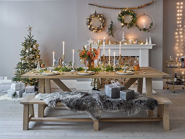 A festive scandi inspired dining room with a long table, fairy lights and a bar cart