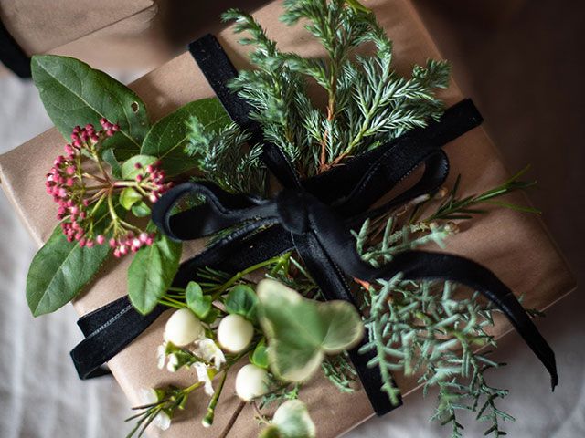 gift wrapping with craft paper, ribbon and foliage for Christmas - christmas foliage styling ideas - living room - goodhomesmagazine.com 