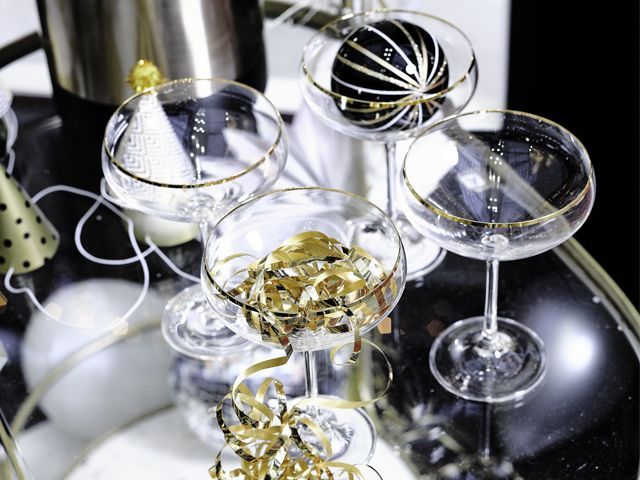 cocktail glasses on a glass bar cart with party accessories at the Ideal Home Show Good Homes roomset