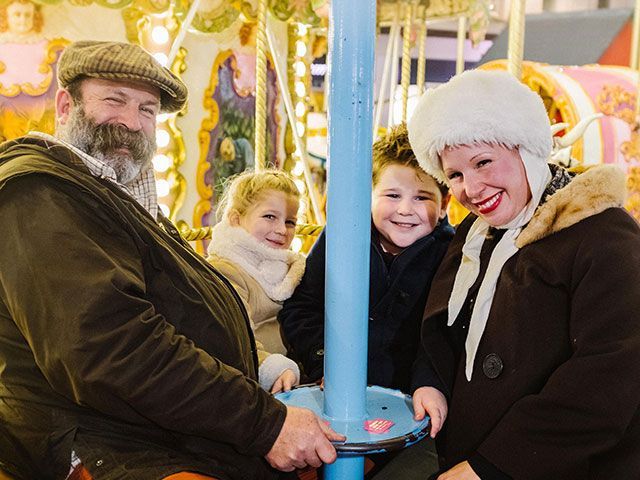 Dick Strawbridge and Angel Adoree with their kids on a fairground ride from Channel 4's Escape to the Chateau - home tours - goodhomesmagazine.com