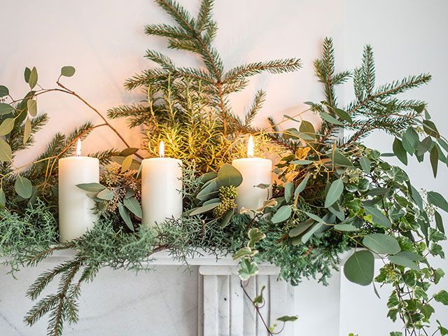 Pillar candles with plant foliage on a mantelpiece - Christmas foliage styling ideas - living room - goodhomesmagazine.com