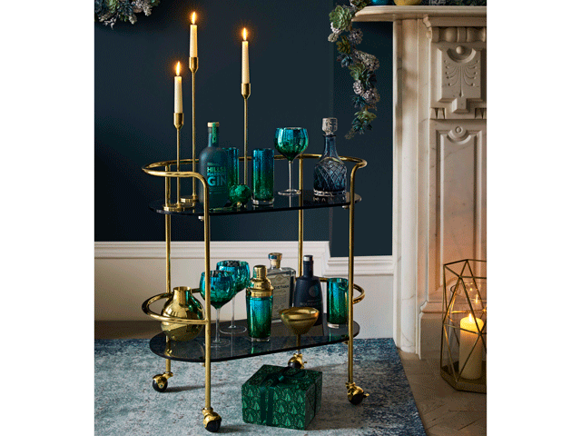 a gold trim bar cart with cocktail accessories in a teal blue living room from John Lewis AW18