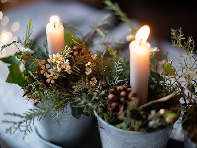 plants with candles as a centrepiece on a dining table at Christmas - Christmas foliage styling ideas - living room - goodhomesmagazine.com