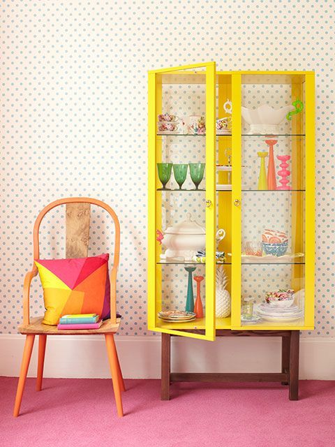 Bright yellow vintage display cabinet full of retro china and glassware