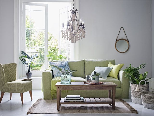 Green sofa in botanical themed living room -m-s-living-room-goodhomesmagazine.com