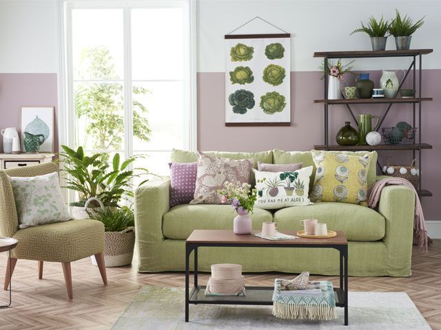 Green sofa in a living room with purple painted and botanical home accessories living-room-goodhomesmagazine.com