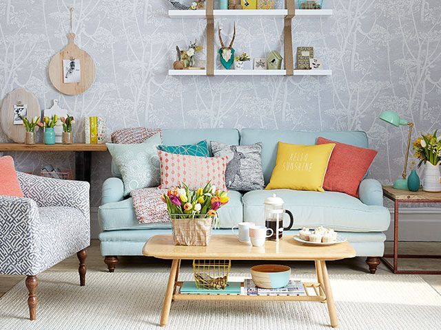 A modern country living room with grey cow parsley wallpaper, light blue sofa, mid-century furniture and yellow accents