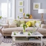 A neutral sofa with yellow and green cushions with a spring theme