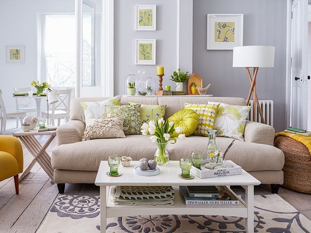 A neutral sofa with yellow and green cushions with a spring theme