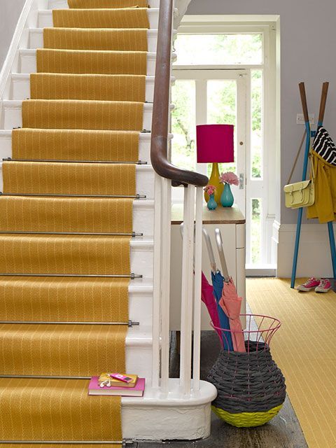 A yellow stair runner in a traditional entrance hallway of a period house