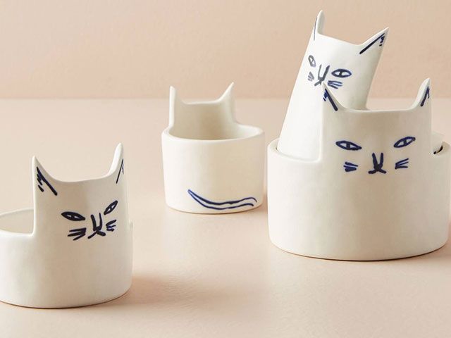 White bowls with pointed cat ears and cat faces drawn on in blue ink