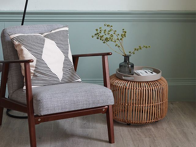 Nordic style reading corner with armchair and rattan side table 