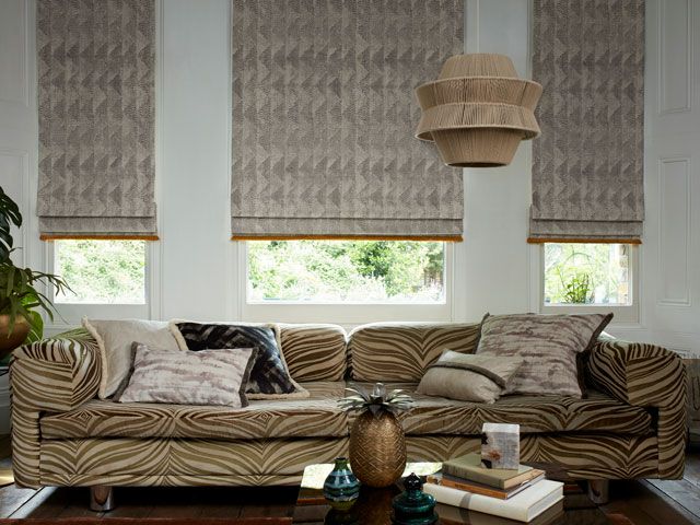 Asaro mink Roman blinds with Colette Soleil fringing in a living room by Abigail Ahern for Hillarys 
