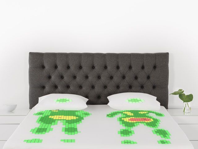 A bed with a grey headboard dressed with white bedding and a green heat map drawn on top of the bedding to show how the contours of the human body fit on the mattress -unikbed-bedrooms-goodhomesmagazine.com