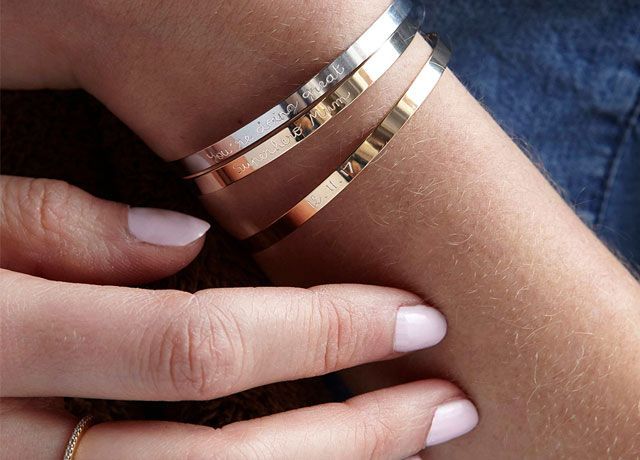 Woman's hand modelling gold and silver personalised bangles from Merci Maman -notonthehighstreet-living-room-goodhomesmagazine.com