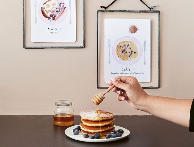 Honey and blueberry pancakes served up in dining room decorated with personalised pancake illustrations -notonthehighstree-living-room-goodhomesmagazine.com