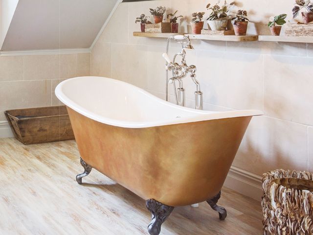 imperium feet bath in gold burnished by albion in a bathroom with houseplants