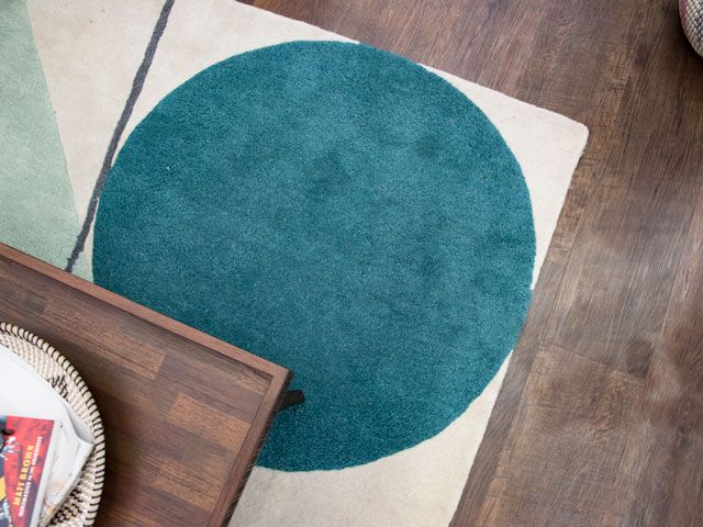wood flooring layered with a rug and coffee table in a living room inspired by Charles and Camilla in the Good Homes roomsets at Ideal Home Show 2019