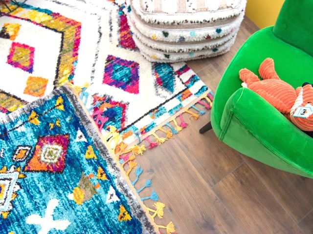 colourful print rugs with a contrasting green chair at good homes roomsets at Ideal Home Show 2019