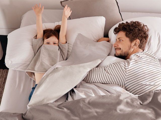 Picture of a father and son sleeping in a Casper bed -casper-bedroom-goodhomesmagazine.com