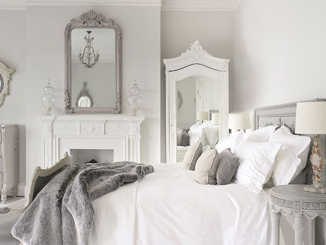 Grey shabby chic bedroom with pillows piled up on a bed
