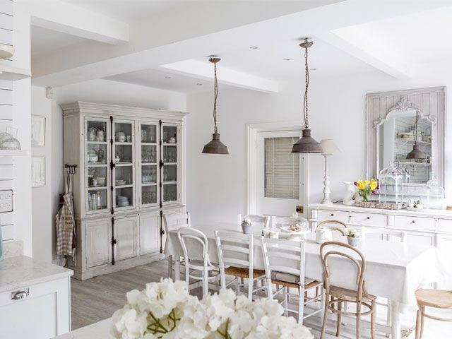 A photo of the Plum Guide house. the Ivory Mansion's white kitchen with white dining table and chairs and a white storage cabinet -living-room-goodhomesmagazine.com