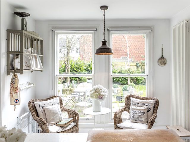 Photo of the kitchen of the Plum Guide House, the Ivory Mansion with two wicker chairs placed in front a window that looks out to the garden -living-room-goodhomesmagazine.com