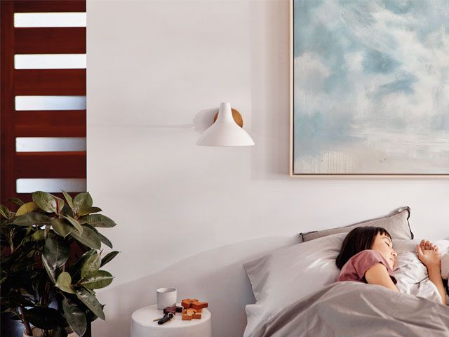 Picture of a woman sleeping in a Casper bed in a white painted bedroom -casper-bedroom-goodhomesmagazine.com